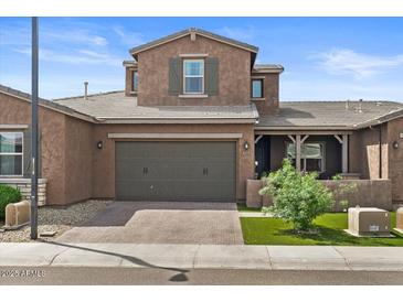 Charming two-story home showcasing a well-manicured lawn and a covered porch area at 1906 N 140Th Dr, Goodyear, AZ 85395