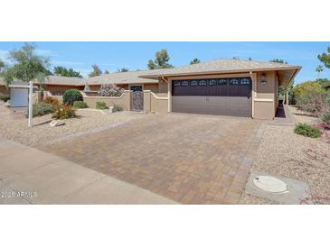 Charming home with a two-car garage, paver driveway, and desert landscaping at 19215 N Concho Cir, Sun City, AZ 85373