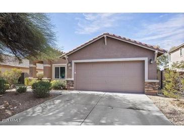 Inviting single-story home with a two-car garage and well-maintained landscaping at 21570 N Greenway Rd, Maricopa, AZ 85138