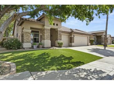 Beautiful single-story home with stone accents and a three-car garage on a well-maintained lawn at 2226 W Periwinkle Way, Chandler, AZ 85248
