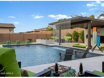 Stunning backyard pool with water feature, covered patio, and lounge seating; perfect for outdoor entertaining at 5457 S Benton --, Mesa, AZ 85212