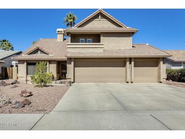 Inviting two-story home featuring a three-car garage and desert landscaping in a sunny locale at 6938 W Wescott Dr, Glendale, AZ 85308