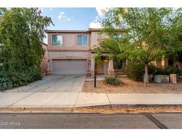 Inviting two-story home showcasing desert landscaping, a two-car garage, and covered front porch at 1222 E Canyon Trl, San Tan Valley, AZ 85143