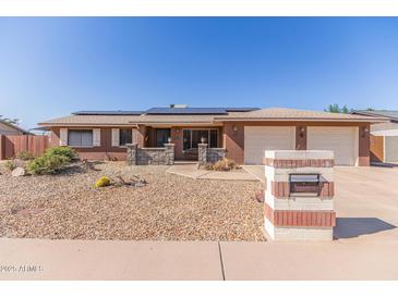 Charming single-story home featuring a two-car garage, solar panels, and low-maintenance landscaping at 1348 W Rockwood Dr, Phoenix, AZ 85027