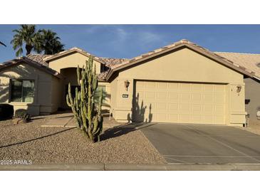 Charming home featuring a two-car garage, desert landscaping and mature cacti for added curb appeal at 14878 W Verde Ln, Goodyear, AZ 85395