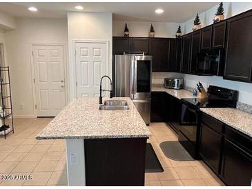 Bright, modern kitchen features a large island, stainless appliances and dark cabinetry at 1718 S 82Nd Way, Mesa, AZ 85209