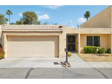 Charming single-story home featuring a tan exterior, a two-car garage, and a well-manicured lawn at 2116 W Marlette Ave, Phoenix, AZ 85015