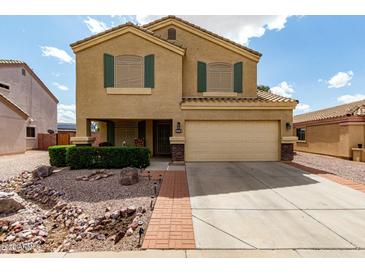 Inviting two-story home featuring a two-car garage, desert landscaping, and a covered front porch at 309 W Settlers Trl, Casa Grande, AZ 85122