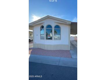 Charming home exterior featuring arched windows and a well-maintained yard, perfect for comfortable living at 320 E Mckellips Rd # 152, Mesa, AZ 85201