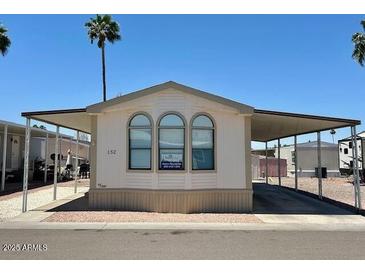 Charming single-Gathering home featuring a covered carport and well-maintained landscaping at 320 E Mckellips Rd # 152, Mesa, AZ 85201