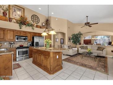 Open-concept kitchen features stainless steel appliances, tile floors, and spacious island with granite countertops at 4720 E Bighorn Ave, Phoenix, AZ 85044