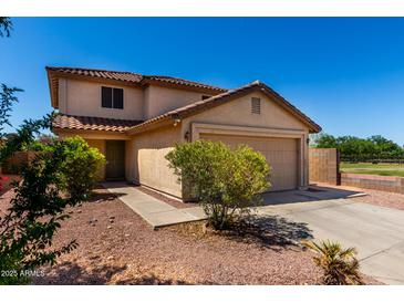 Charming two-story home with a well-maintained front yard, desert landscaping, and attached garage at 11841 W Laurel Ln, El Mirage, AZ 85335