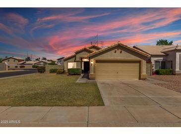 Charming single-story home boasts a well-manicured lawn and neutral-toned exterior with a two-car garage at 1350 E Vaughn Ave, Gilbert, AZ 85234