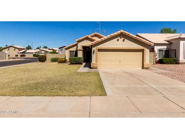 Charming single-story home featuring a well-maintained lawn and a two-car attached garage at 1350 E Vaughn Ave, Gilbert, AZ 85234