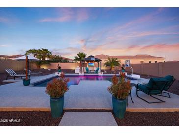 A beautiful backyard pool with a gazebo, basketball court, and plenty of seating for entertaining at 14979 S 184Th Ave, Goodyear, AZ 85338