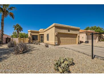 Southwest-style home featuring desert landscaping, including gravel, cacti, and a two-car garage at 17323 E Teal Dr, Fountain Hills, AZ 85268