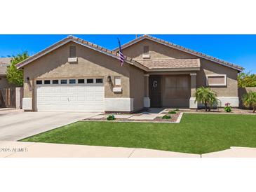 Charming single-story home featuring an attached two-car garage, manicured lawn, and desert landscaping at 1926 S Longspur Ln, Gilbert, AZ 85295