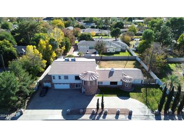 Aerial view of a landscaped property featuring unique turret design and mature trees at 333 W Bethany Home Rd, Phoenix, AZ 85013
