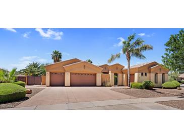 Charming single-story home with a three-car garage, desert landscaping and mature palm trees at 4204 S Winter Ln, Gilbert, AZ 85297