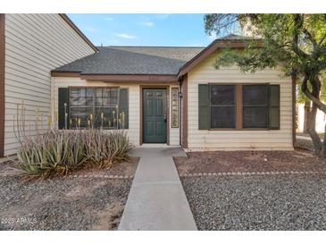 Charming front entrance with tidy landscaping and dark green door at 6611 W Kingston Ln, Glendale, AZ 85306