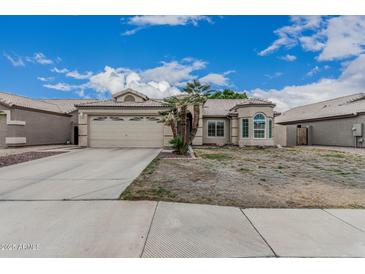 Charming single-story home with a spacious driveway and two-car garage at 705 W Country Estates Ave, Gilbert, AZ 85233