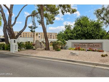 View of the Scottsdale Shadows sign and building in a well maintained community under a blue sky at 7840 E Camelback Rd # 110, Scottsdale, AZ 85251