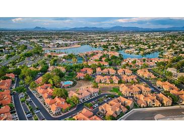 Stunning aerial view of the property with lake, tennis courts, pool and surrounding neighborhood and mountain views at 1633 E Lakeside Dr # 98, Gilbert, AZ 85234