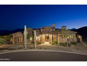 Stunning desert home with stone accents, lush landscaping, and mountain views at twilight at 16716 S 32Nd Ln, Phoenix, AZ 85045