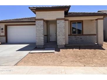 Charming single-story home featuring a brick facade, a driveway, and a well-manicured lawn at 20615 N 226Th Dr, Surprise, AZ 85387