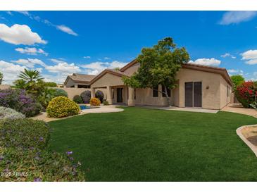 Expansive backyard with lush green grass, mature trees, and a sparkling pool at 22322 N 77Th St, Scottsdale, AZ 85255