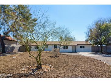Charming single-story home featuring desert landscaping and a classic white exterior, perfect for low-maintenance living at 3249 E Sunnyside Ln, Phoenix, AZ 85032