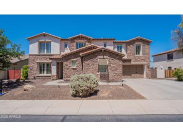 Charming two-story home with stone accents, a well-manicured lawn, and a welcoming two car garage at 3574 E Glacier Pl, Chandler, AZ 85249