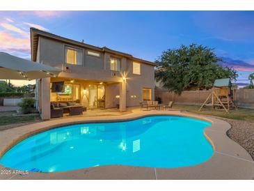 Inviting backyard showcasing a sparkling pool, covered patio, and lush green lawn perfect for outdoor entertaining at 4093 E Dublin St, Gilbert, AZ 85295