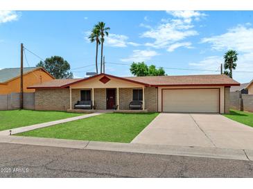 Charming single-story home with a well-manicured lawn and a two-car garage at 4333 E Desert Cactus St, Phoenix, AZ 85032