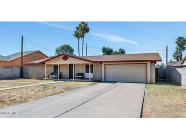 Charming single-story home featuring a two-car garage and a cozy front porch with two benches at 4333 E Desert Cactus St, Phoenix, AZ 85032