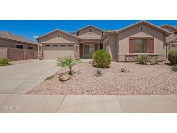Charming single-story home featuring a low-maintenance desert landscape and a two-car garage at 44574 W Garden Ln, Maricopa, AZ 85139