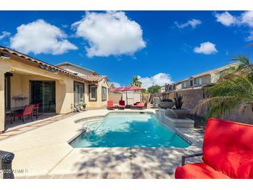 Relaxing backyard pool with patio furniture, lush landscaping, and sunny skies create a private oasis at 455 W Honeysuckle Dr, Chandler, AZ 85248