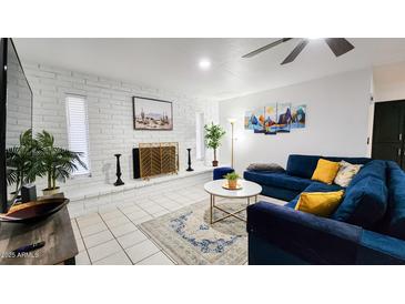 Bright living room with white brick fireplace, modern decor, and comfortable blue sofa at 5309 W Dahlia Dr, Glendale, AZ 85304