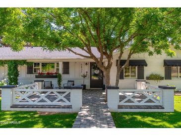 Charming white brick home with a welcoming front entrance and meticulously landscaped front yard at 6837 E Lafayette Blvd, Scottsdale, AZ 85251