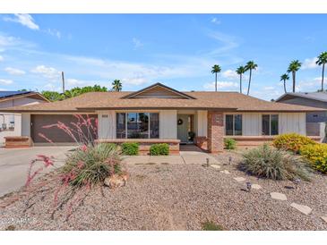 Charming single-story home featuring a well-manicured front yard and a welcoming brick accented entryway at 928 W Natal Ave, Mesa, AZ 85210
