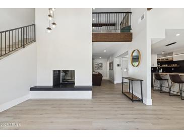 Bright living room featuring modern fireplace, hardwood floors, with a view of the upper level at 15027 N 19Th Way, Phoenix, AZ 85022