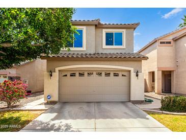 Inviting two-story home with a spacious garage, well-maintained landscaping, and neutral exterior paint at 1944 N Lazona Dr, Mesa, AZ 85203