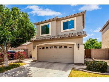 Inviting two-story home with a spacious garage, well-maintained landscaping, and neutral exterior paint at 1944 N Lazona Dr, Mesa, AZ 85203