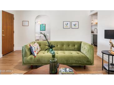 Stylish living room featuring a green sofa, art and wood-look floors at 3115 N 34Th Pl, Phoenix, AZ 85018