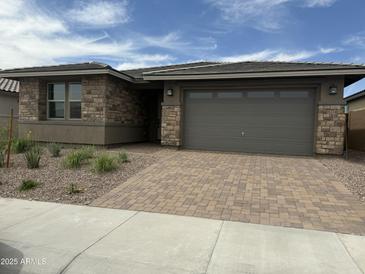 Charming single-story home featuring brick accents, desert landscaping, and a two-car garage with paver driveway at 31274 N 130Th Ave, Peoria, AZ 85383