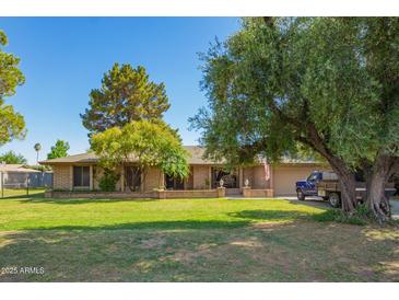 Charming single-story brick home with a well-maintained lawn, mature trees, and inviting curb appeal at 6637 W Pershing Ave, Glendale, AZ 85304