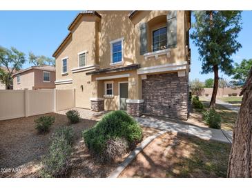 Two-story home with a desert-landscaped yard and a combination of stone and stucco exterior finishes at 9233 E Neville Ave # 1125, Mesa, AZ 85209