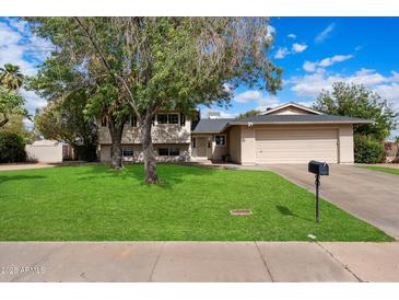 Charming two-story home with a well-maintained lawn and mature trees in a quiet neighborhood at 13411 N 50Th St, Scottsdale, AZ 85254