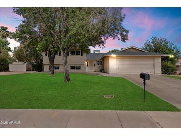 Charming two-story home with a well-manicured front yard, mature trees, and an attached two-car garage at 13411 N 50Th St, Scottsdale, AZ 85254