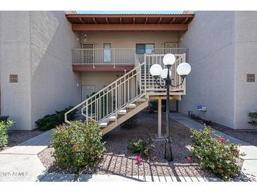 A condo exterior showing the entryway with stairs and landscaping for a clean, inviting look at 205 N 74Th St # 201, Mesa, AZ 85207
